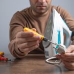 Biały mężczyzna naprawiający złamane żelazo