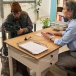 Assisting homeless middle aged man during social services consultation meeting