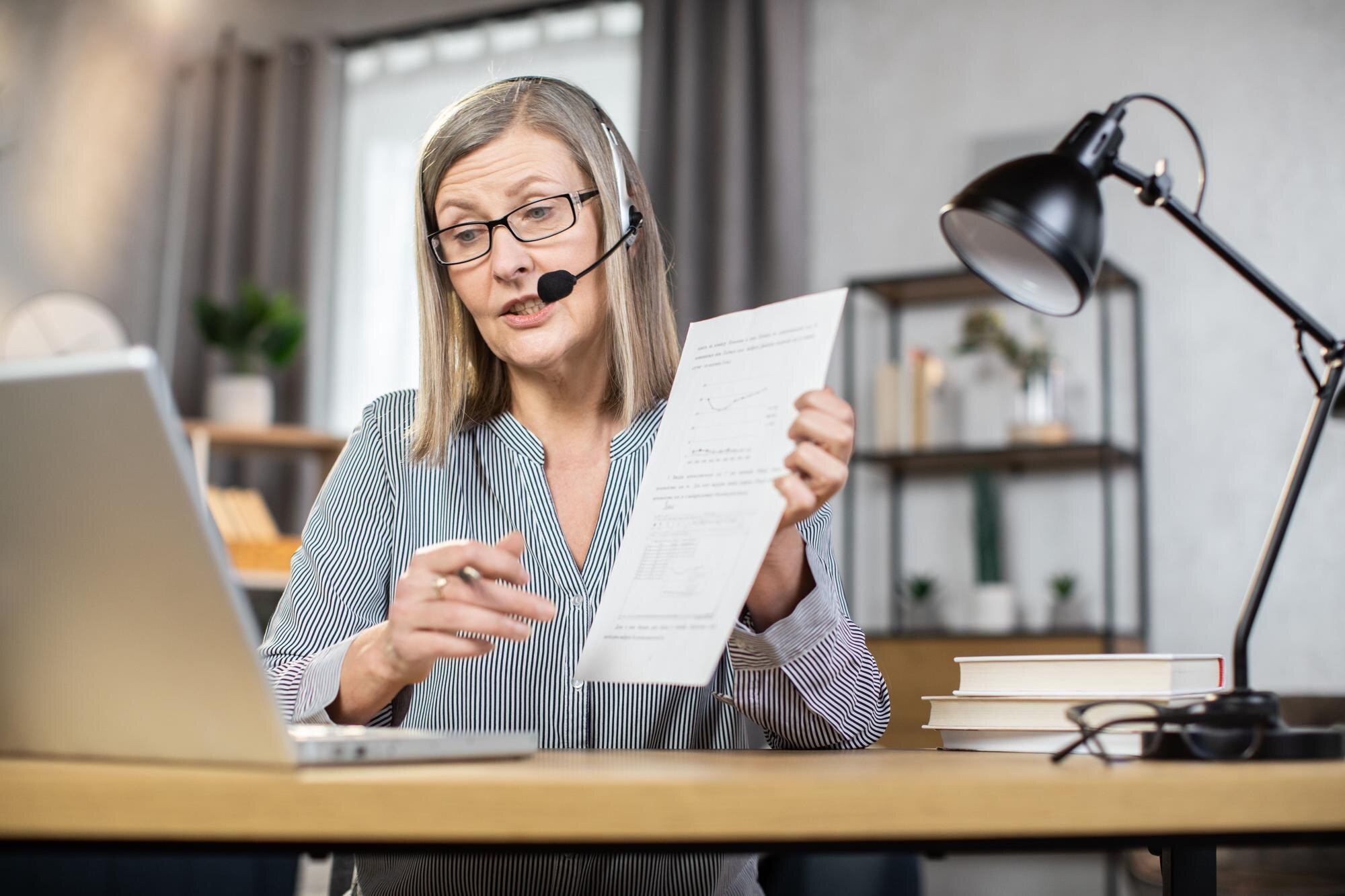 Starsza kobieta na czacie online ze współpracownikami z domu