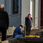 Grodno Białoruś 21 października 2018 grupa budowniczych zaangażowanych w naprawę kościoła katolickiego Układanie nowego chodnika Główny inżynier wskazuje na problemy w pracy