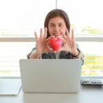 Bizneswomanu mienia czerwony kierowy symbol na stole z komputerem