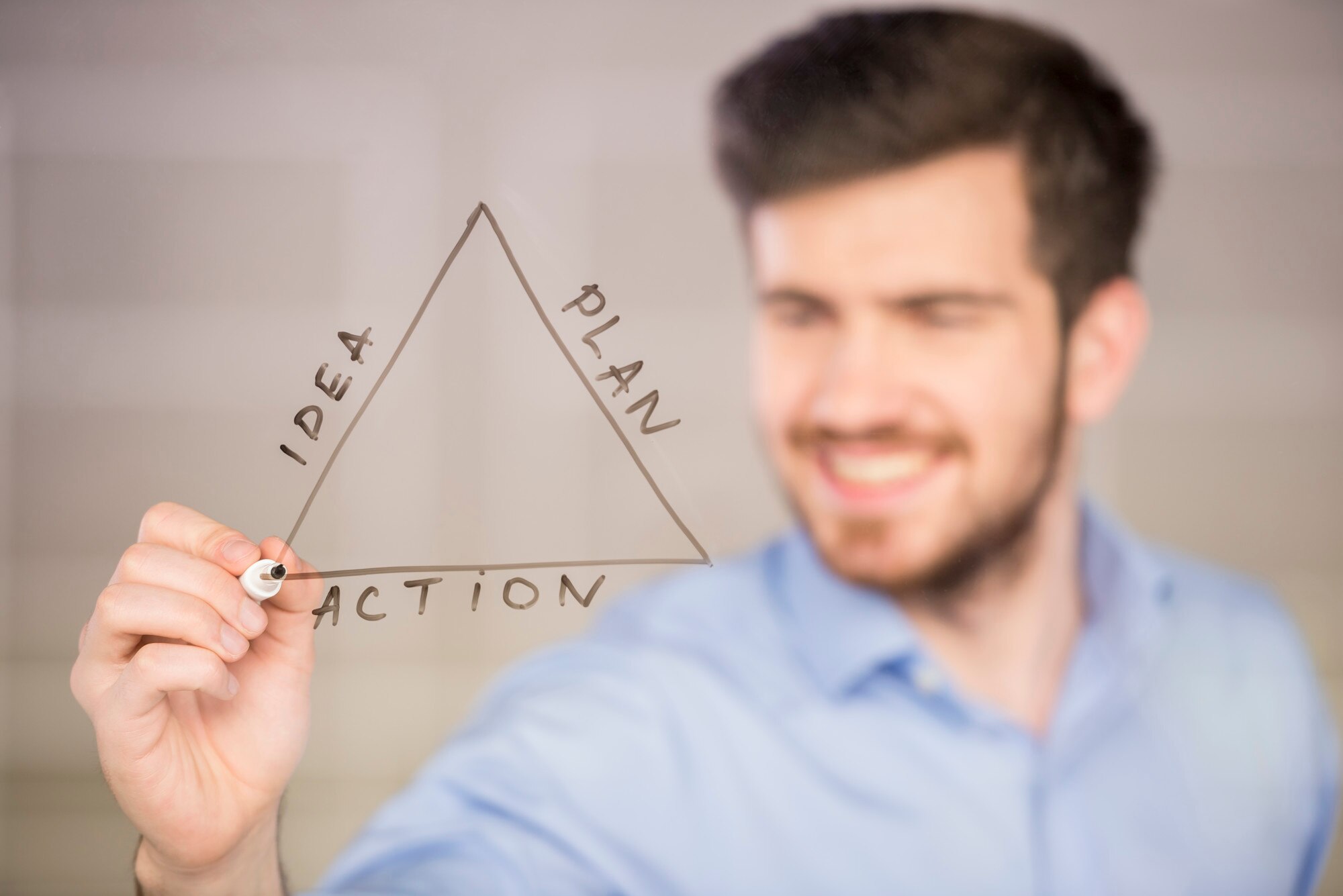 Młody przystojny biznesmen rysunek na szklanym ekranie.