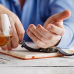 Mężczyzna trzyma kieliszek whisky