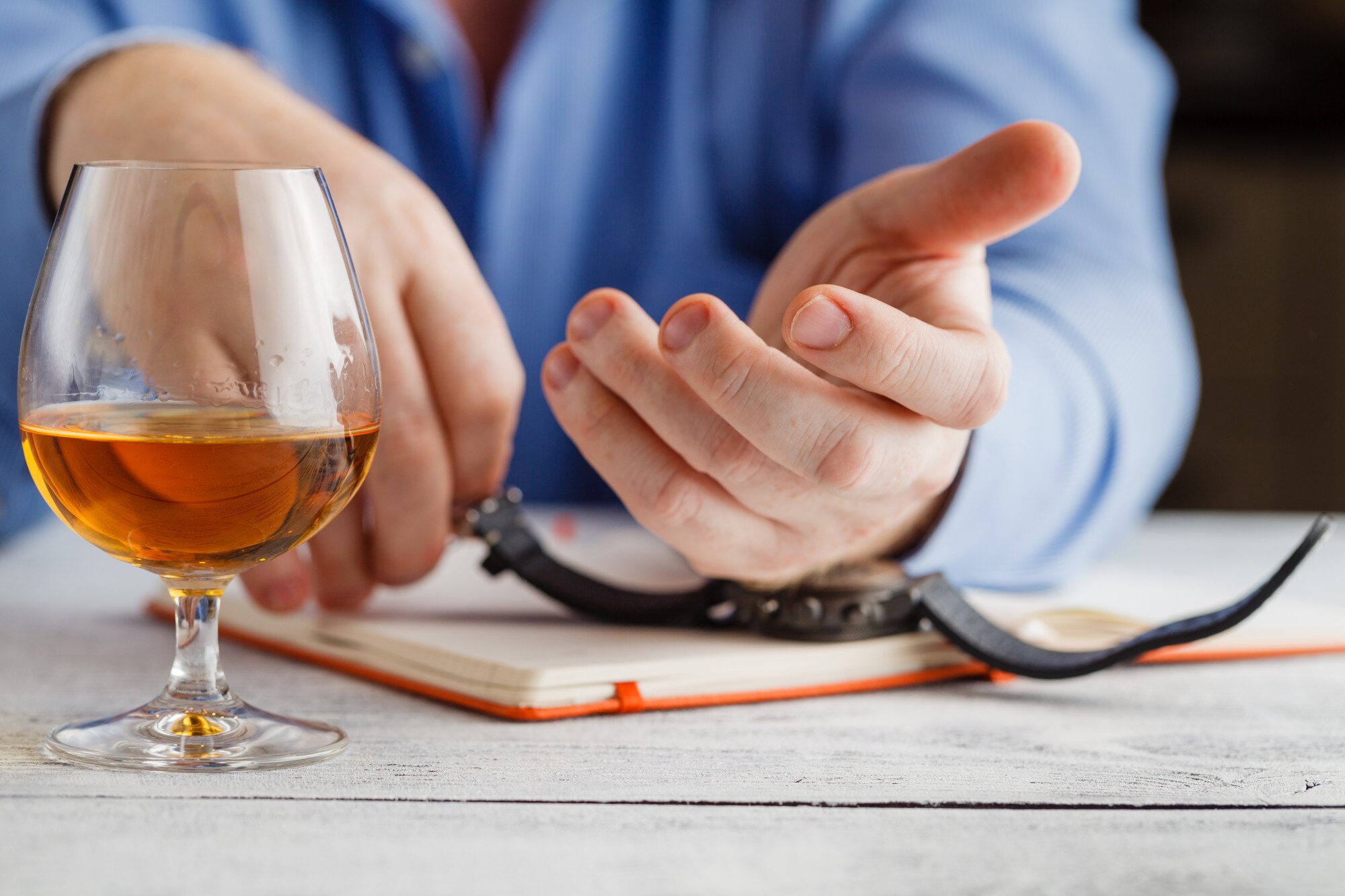 Mężczyzna trzyma kieliszek whisky