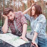 sfrustrowani turyści stoją na zewnątrz i patrzą na mapę