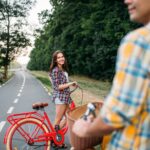 Mężczyzna i młoda kobieta, jazda na rowerach retro. Para na zabytkowych rowerach. Młody mężczyzna i kobieta na starych cyklach, romantyczna randka